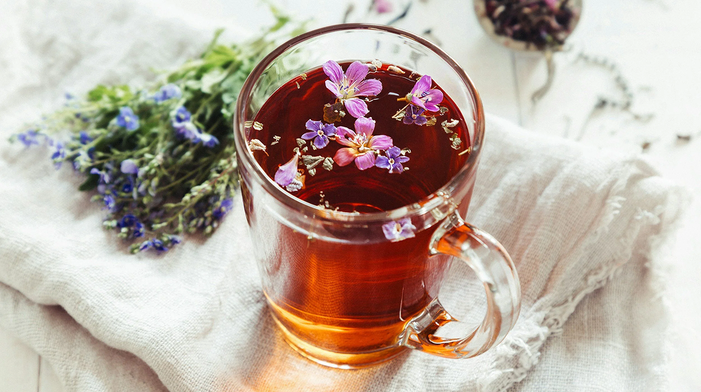 Glass of herbal tea with flowers
